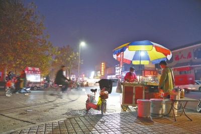 夜幕降临，小蛮夫妻二人在热闹的惠苑街安静地做着美味的烧饼。