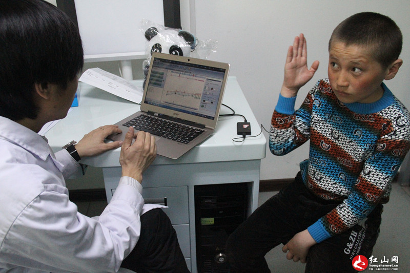 听障患儿吾兰不断给医务人员频频举手示意表明自己听得到了声音。