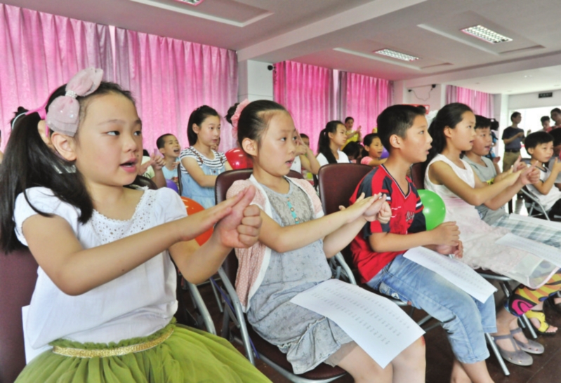 　　在志愿者的帮助下，孩子们认真学习手语。　　□记者　徐志强　摄