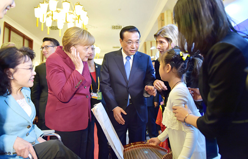 两位总理关心询问张译文带上人工耳蜗后的感受，并欣赏了她的古琴表演。新华社记者 谢环驰 摄