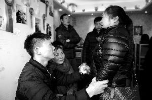25岁的青年大巧（左）虽然无法说话，还一直安慰落泪的亲人。北京晨报记者 郝笑天/摄