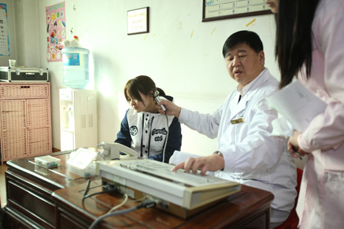 图为中国聋儿康复研究中心专家为听障儿童义诊